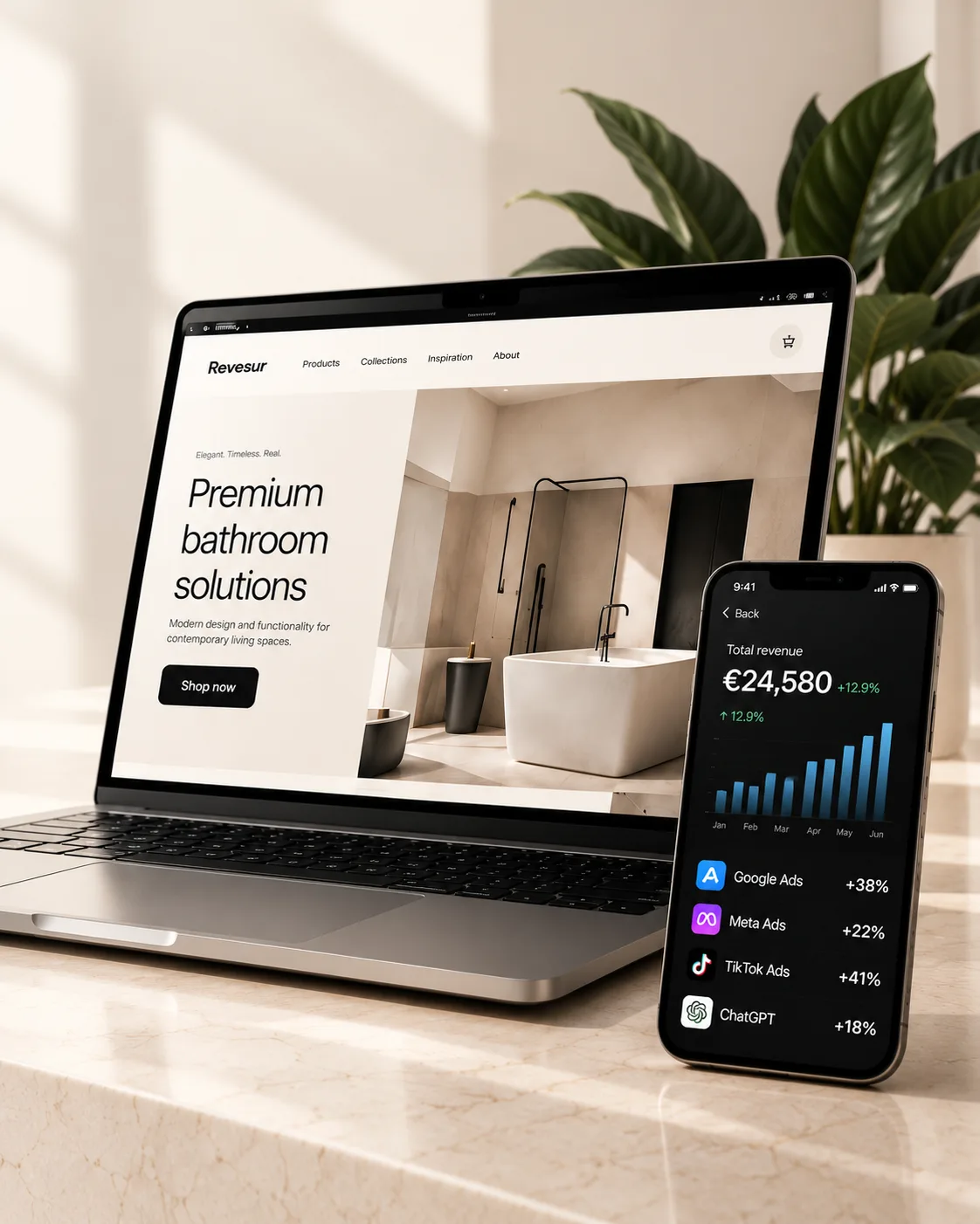 Portátil con una tienda online y móvil con un panel de marketing sobre un escritorio de mármol, junto a una planta